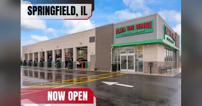 Exterior of the new Plaza Tire Service store in Springfield, Illinois, with open service bays and Springfield, IL and Now Open banners