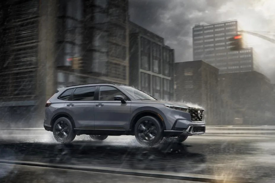 Gray Honda CR-V driving on a wet city street in the rain