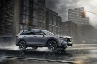 Gray Honda CR-V driving on a wet city street in the rain