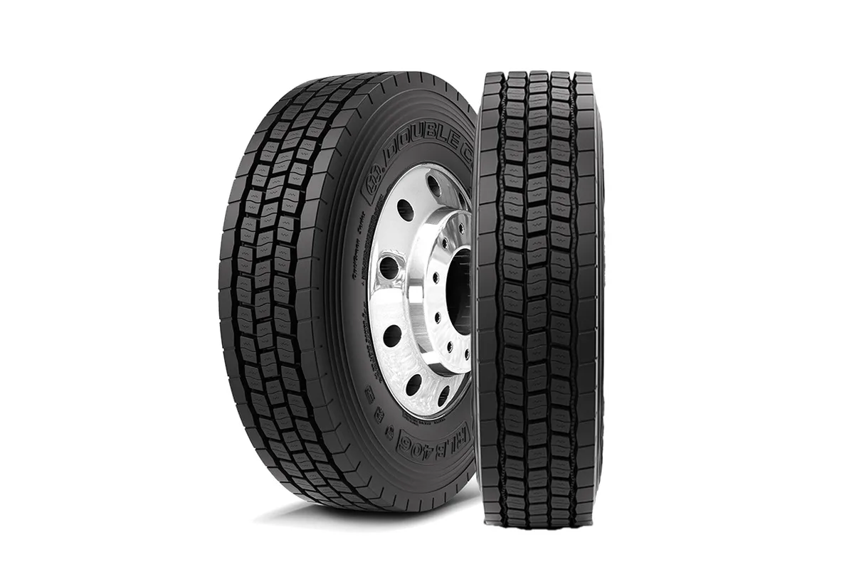 Two Double Coin RLB406 drive tires shown side by side, one angled to show the sidewall and wheel, the other facing forward to show the tread pattern.